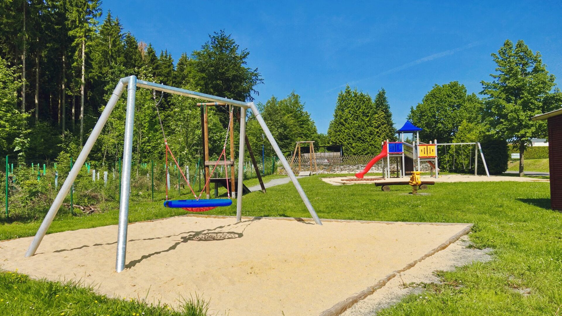 Spielplatz mit Klettergerüst und Schaukel auf dem Campingplatz Paulfeld